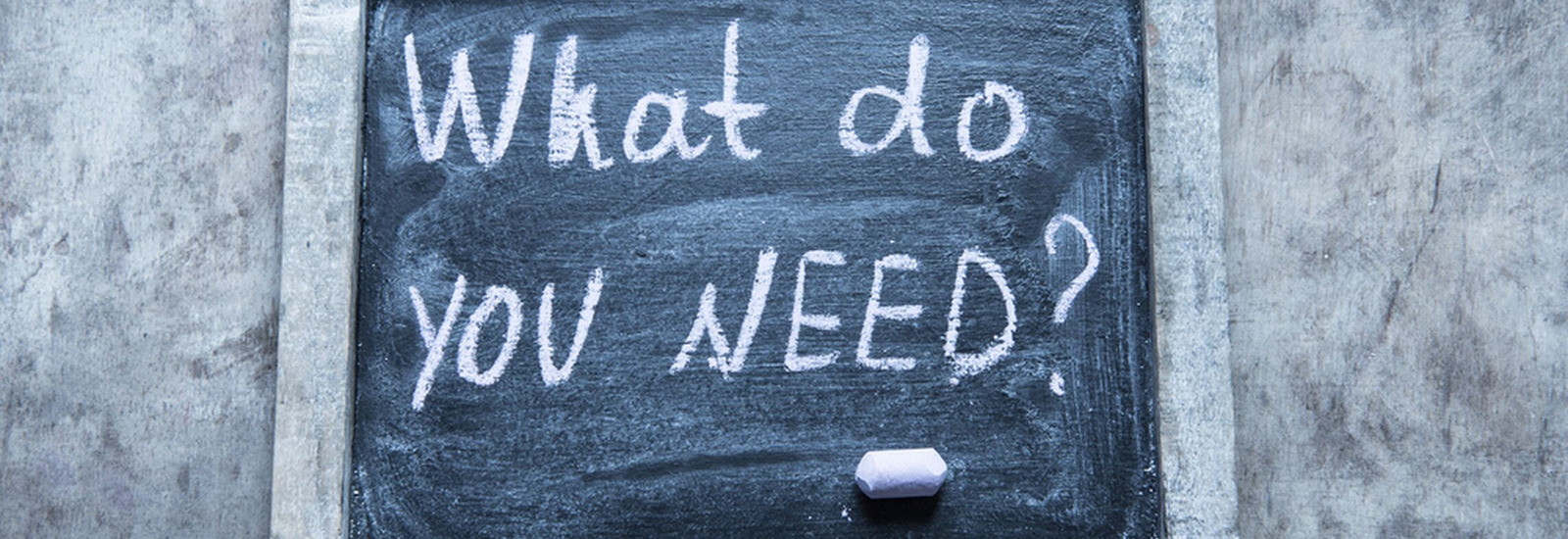 Sign with the words "What do you need" written in white chalk